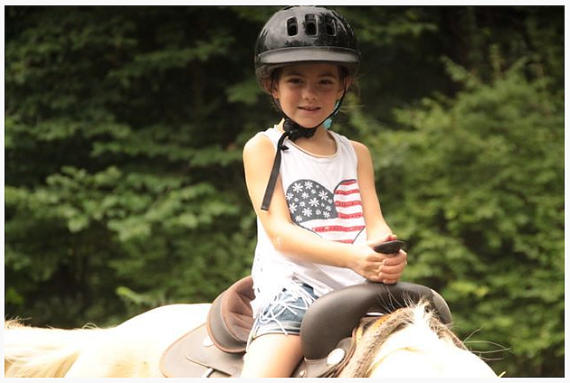 Kathrynn Hudson rides a horse at her first week-long summer camp for military kids at YMCA's Camp Carson back in 2013.