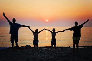 family in silhouette of sunset