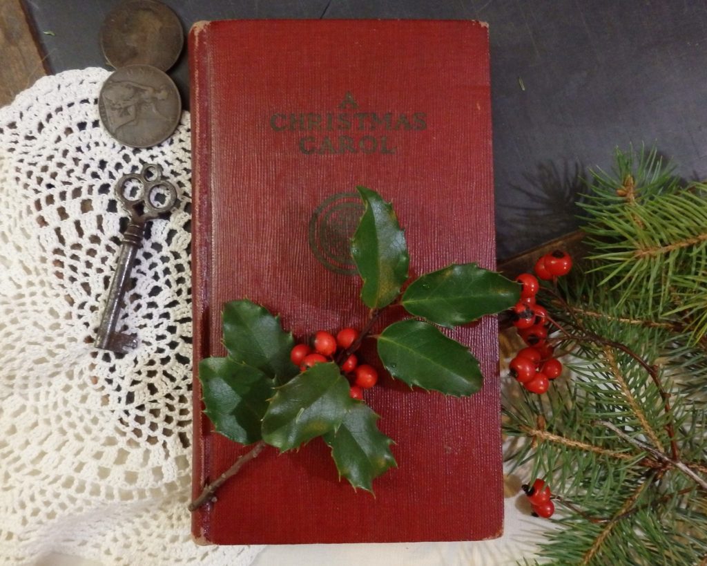 a christmas carol book with holly