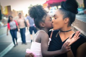 mom kissing daughter's cheek