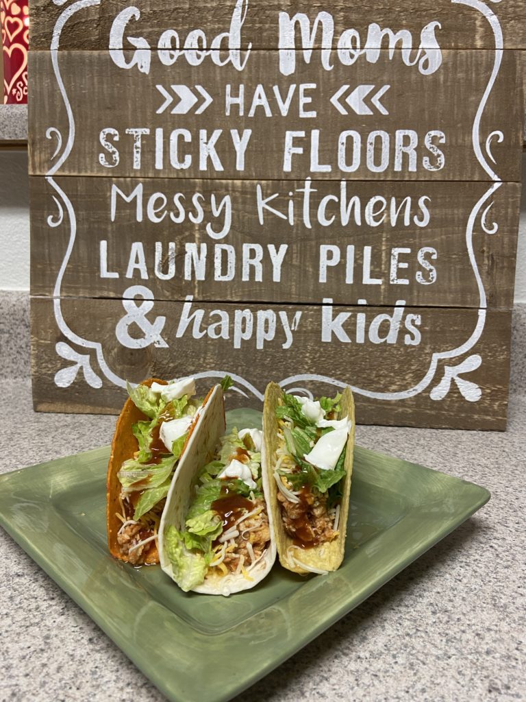 chicken tacos with a wood sign behind the plate