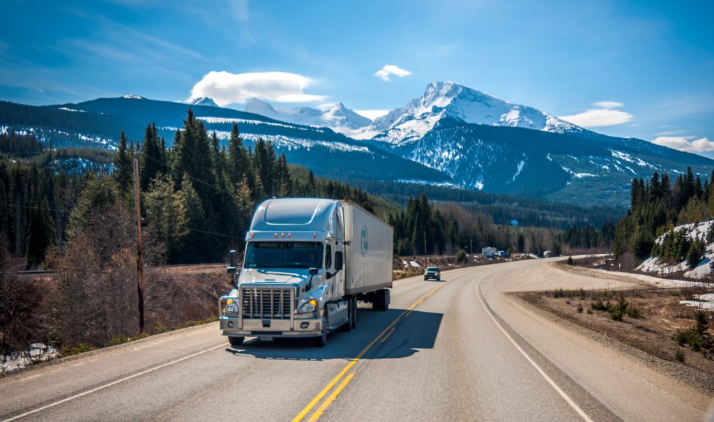 large moving truck on highway through the mountains