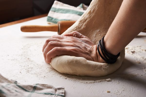 hands kneading dough in recipe