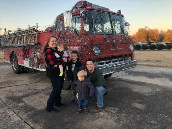 family standing by a firetruck