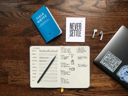 notebooks and laptop on desk promoting education