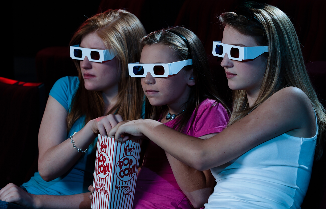 teen girls watching a movie in 3D glasses