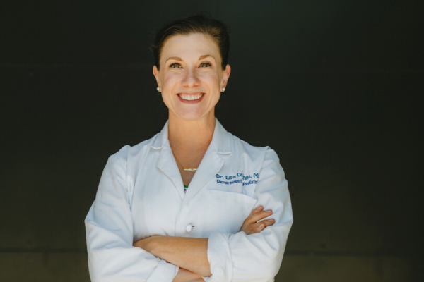 Female Pediatrician in white lab coat, smiling