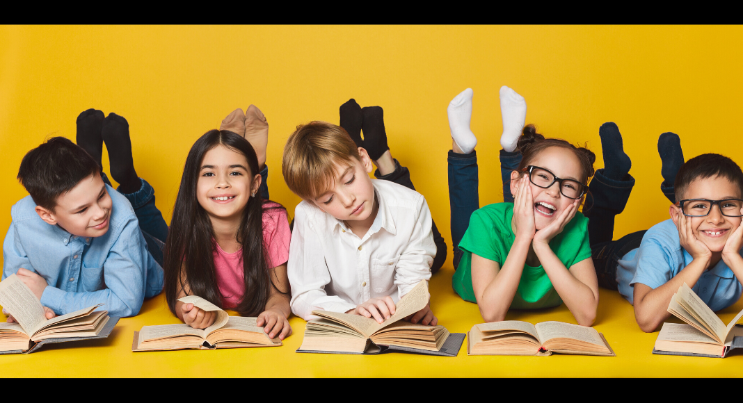 children reading on ground with yellow background