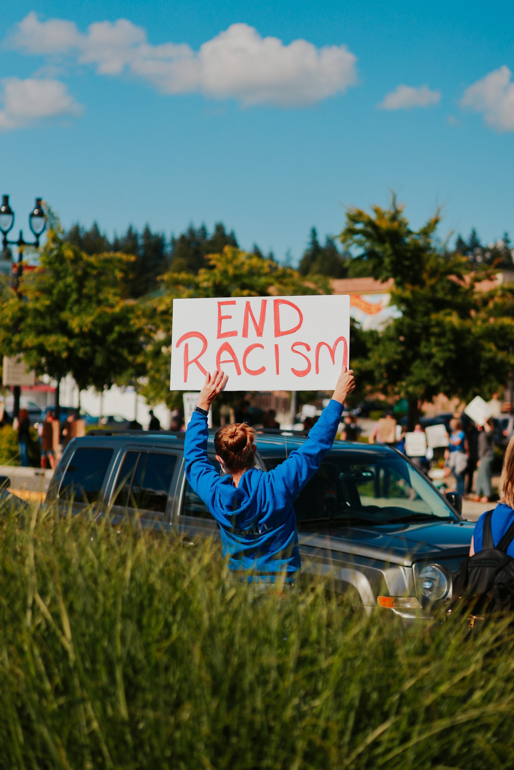 woman holding up sign to end racism