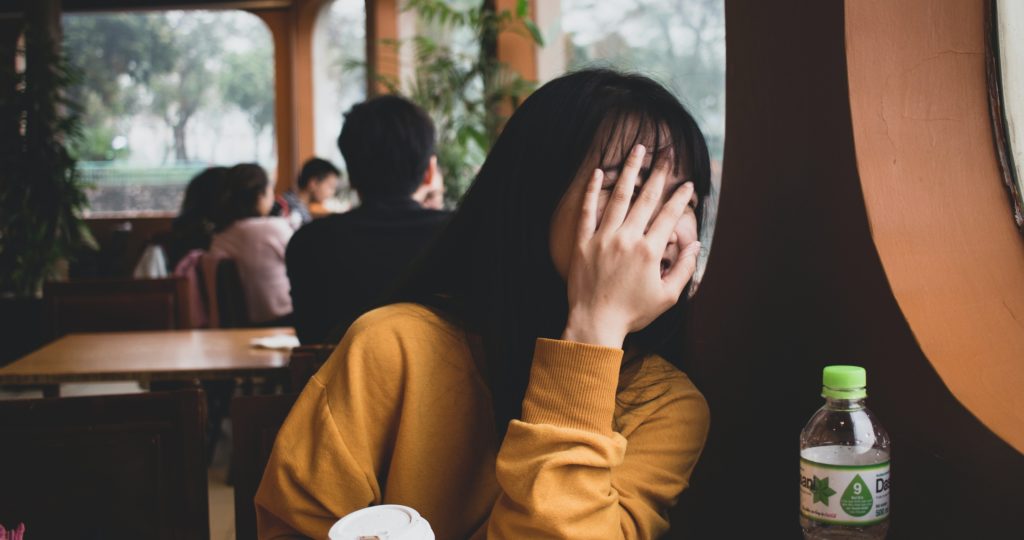 woman covering her embarrassed face