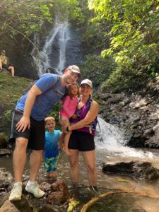 family standing in front of waterfall in Hawaii