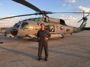 Woman in military uniform standing in front of military helicopter