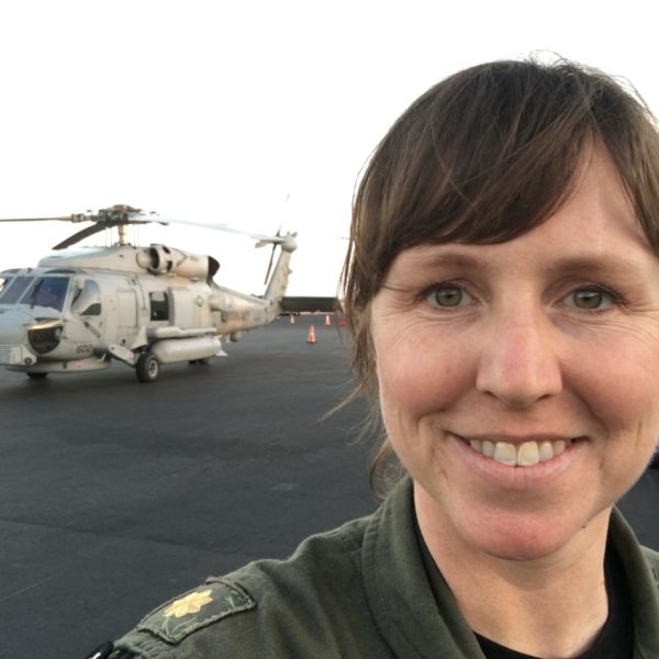 Woman smiling in front of military helicopter