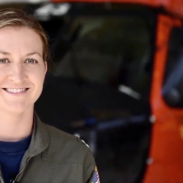 Woman standing in front of military helicopter smiling