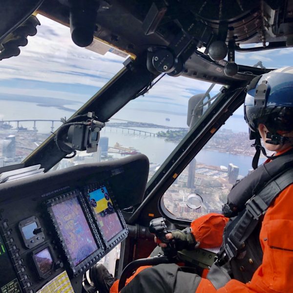 Woman in military uniform flying Coast Guard helicopter