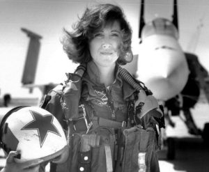 Woman standing in front of military jet in military uniform