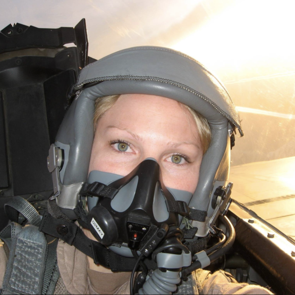 Woman in military jet with helmet on