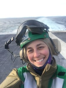 Woman standing on flight deck of aircraft carrier in unifrom