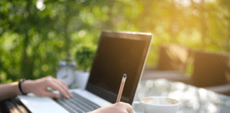 woman writing at table outside