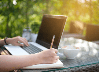 woman writing at table outside