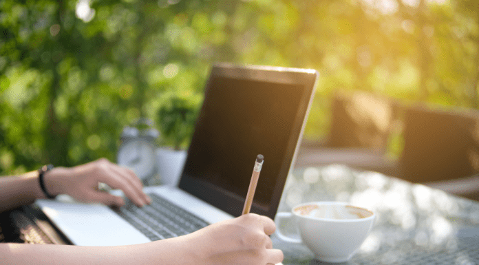 woman writing at table outside