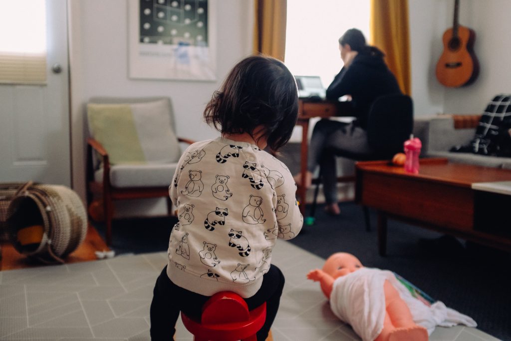 mom working in background with child playing