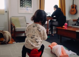 mom working in background with child playing