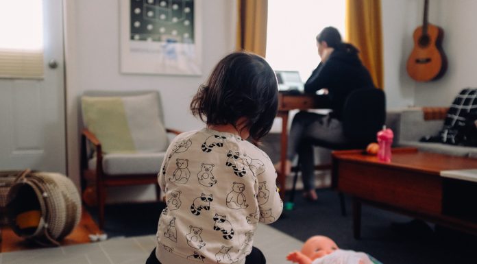 mom working in background with child playing