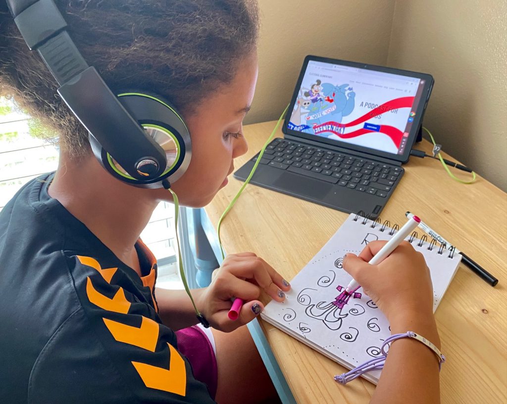 girl drawing and listening to podcast