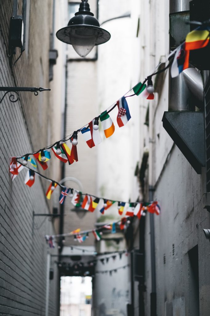 flags from multiple countries in alley