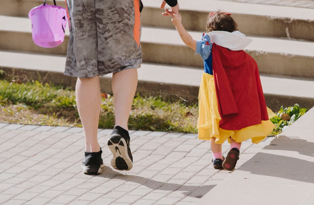 parent trick-or-treating with child in costume