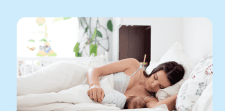 woman breastfeeding in bed on light blue background