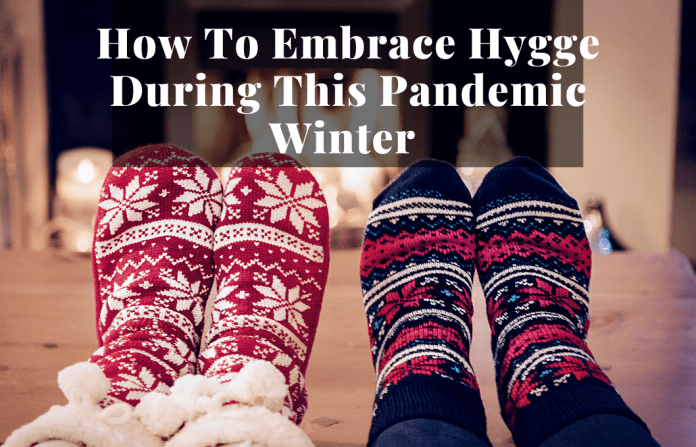 Hygge winter cozy socked feet by fireplace to show hygge