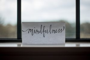 paper with "mindfulness" written on it, sitting on windowsill