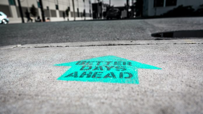 positive arrow on road that reads better days ahead