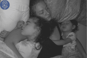 mother sleeping in bed with two daughters