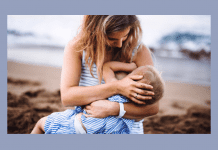 mother breastfeeding toddler on beach