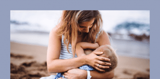 mother breastfeeding toddler on beach