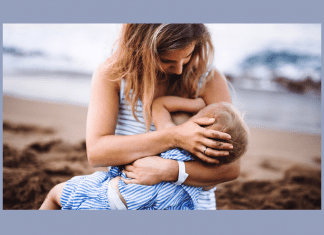 mother breastfeeding toddler on beach