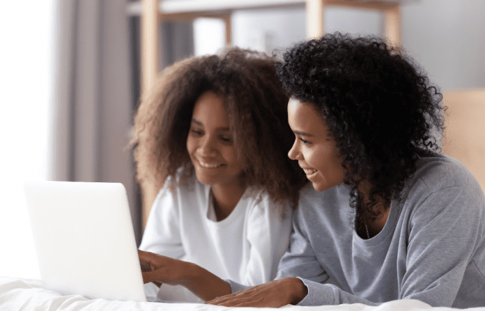 mom and daughter looking on a computer together