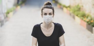 Earthquakes + COVID: The Aftershocks Are Just The Beginning woman sitting on the ground and wearing a protective mask