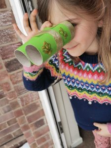 child looking through homemade binoculars