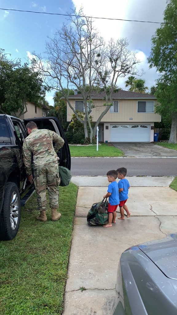 military dad getting in car with sons watching