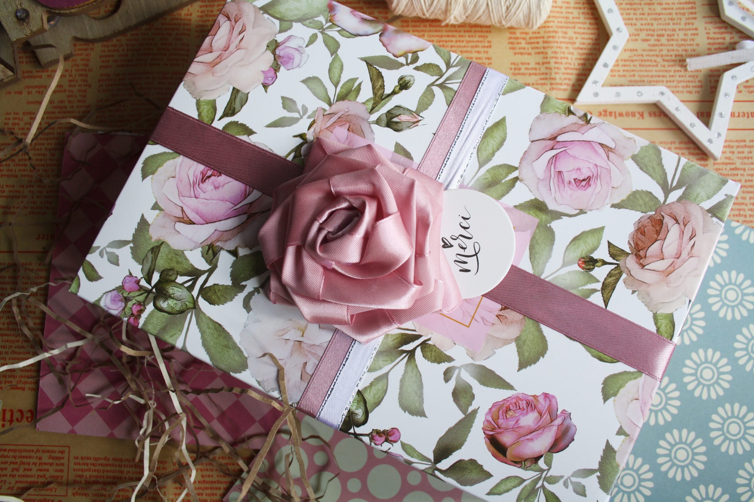 wrapped gift with pink rose bowl and wrapping papers