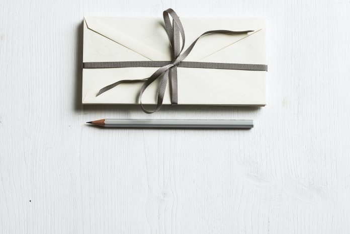 a gift with a bow and a pencil next to it