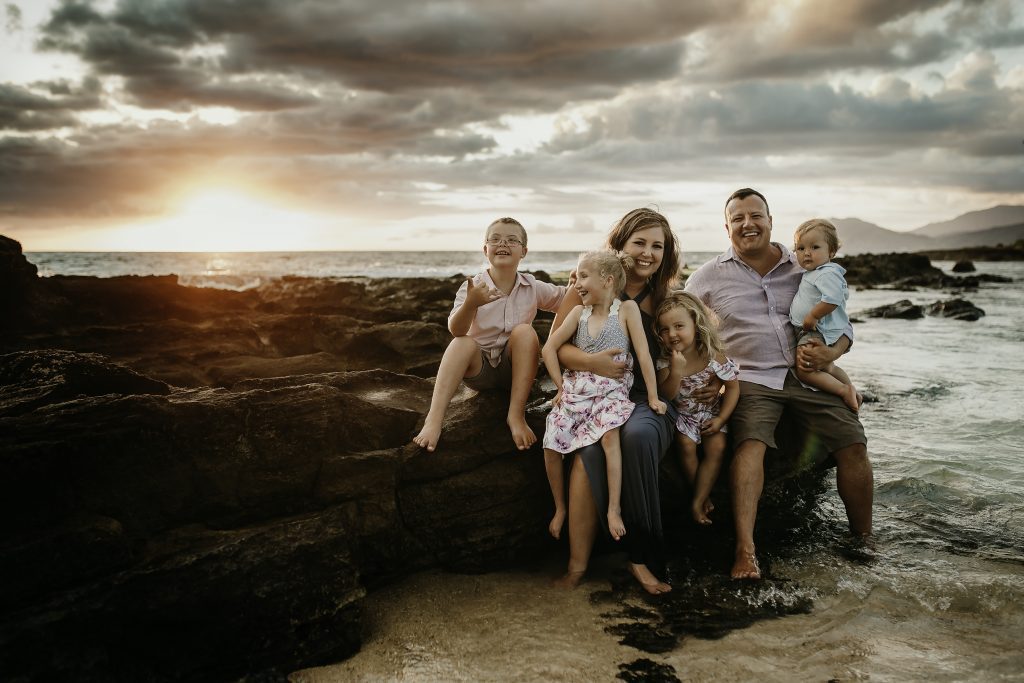 family sitting by the ocean, one child handicapped and one with down syndrome