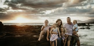 family sitting by the ocean, one child handicapped and one with down syndrome