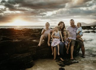 family sitting by the ocean, one child handicapped and one with down syndrome