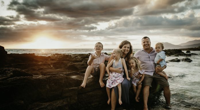 family sitting by the ocean, one child handicapped and one with down syndrome