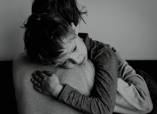 child hugging a parent in black and white